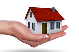 A miniature house in a hand, symbolizing "Property Finder'